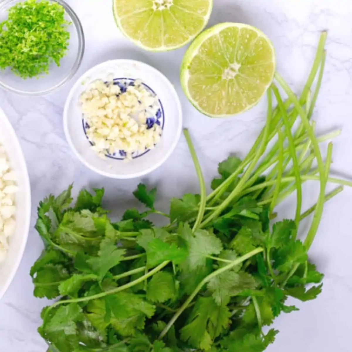Lime, garlic and cilantro on a board.