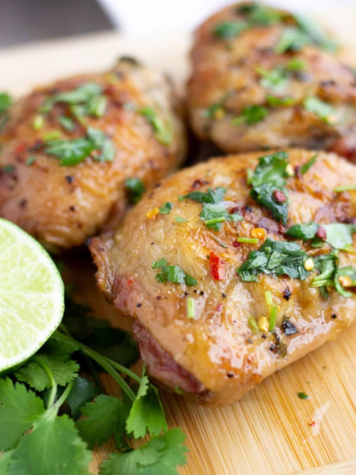 Three pieces of cilantro lime chicken with a slice of lime and cilantro.