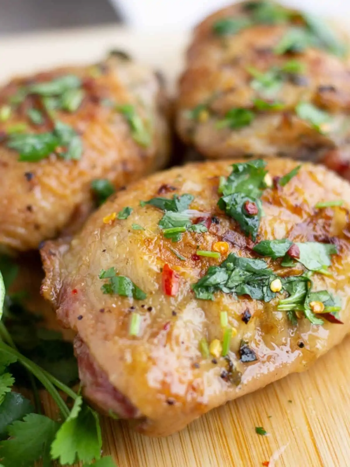 Three pieces of grilled chicken on a cutting board.