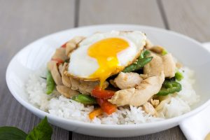 Pad Kra Pao Gai- Thai Spicy Basil with Chicken topped with a fried egg and runny yolk