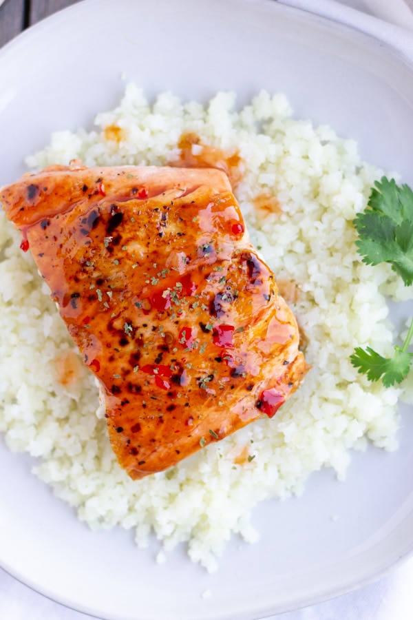 Overhead view of a piece of salmon on a plate with cauliflower rice.
