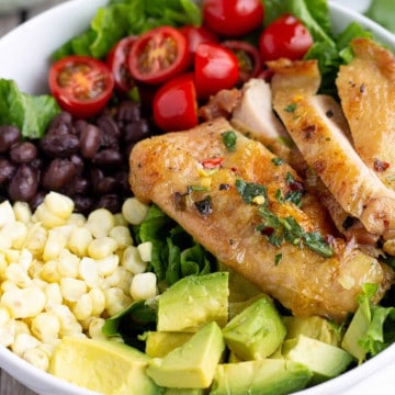 Grilled chicken, avocado, corn, black beans, and tomatoes in a bowl.