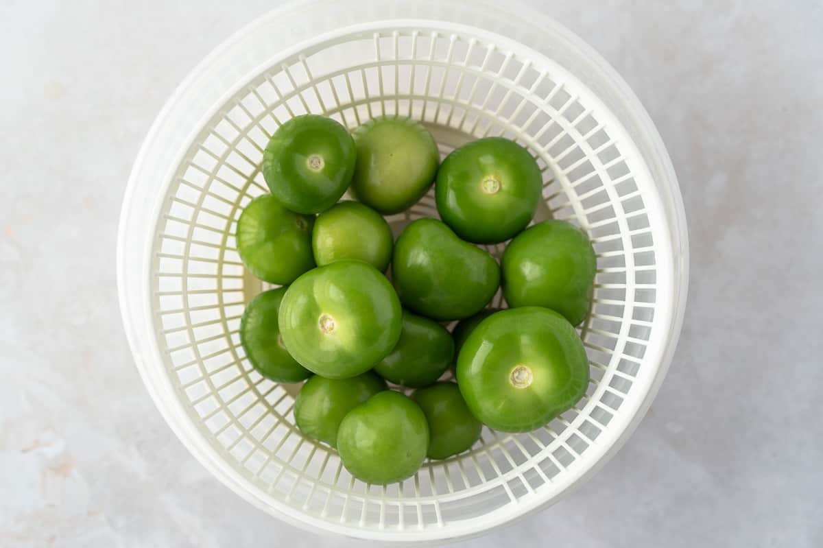 Peeled tomatillos in a colander