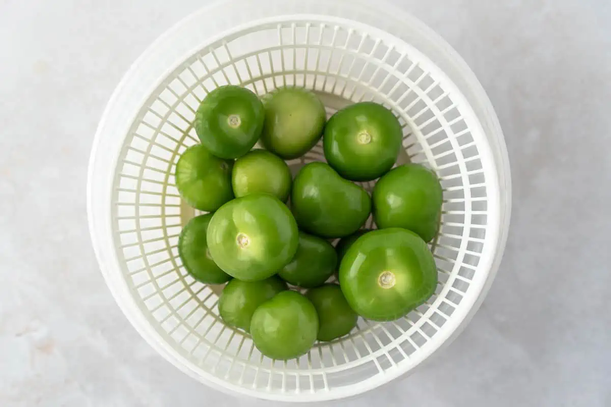 Peeled tomatillos in a colander