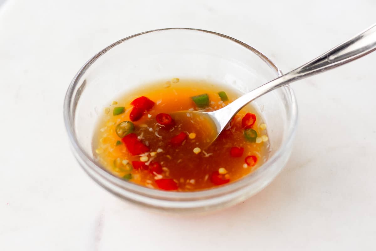 Spicy dressing in a small glass bowl.