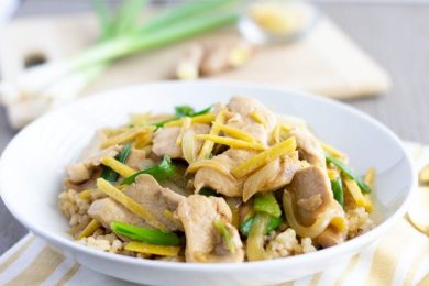 Thai Ginger stir fry in a white bowl served on top of rice.