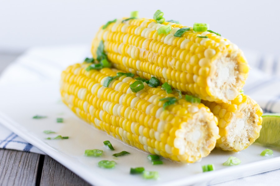 Corn on the cob on a white plate.