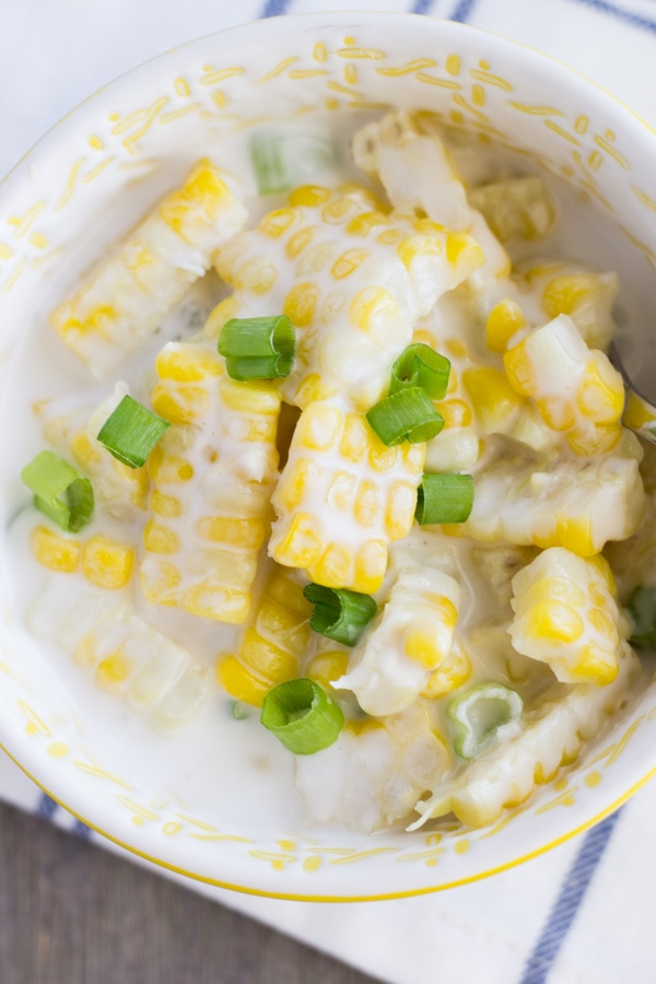 Shaved corn in a yellow bowl with coconut milk.