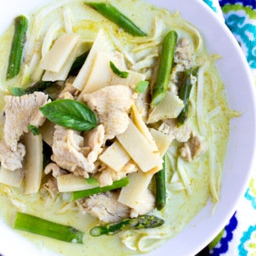 Feature image of green curry in a white bowl with chicken, bamboo, asparagus, and zucchini noodles.