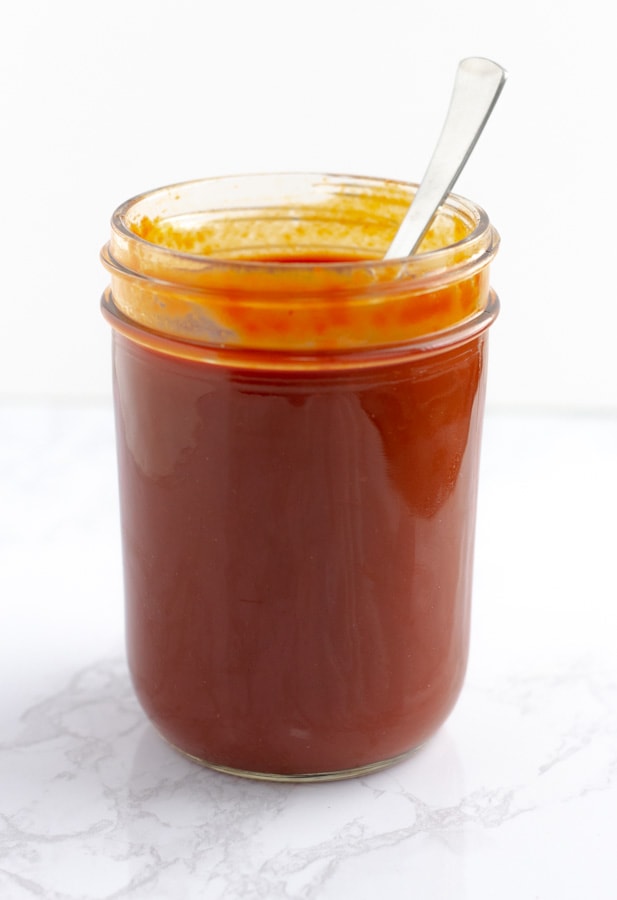 Red enchilada sauce in a glass mason jar.