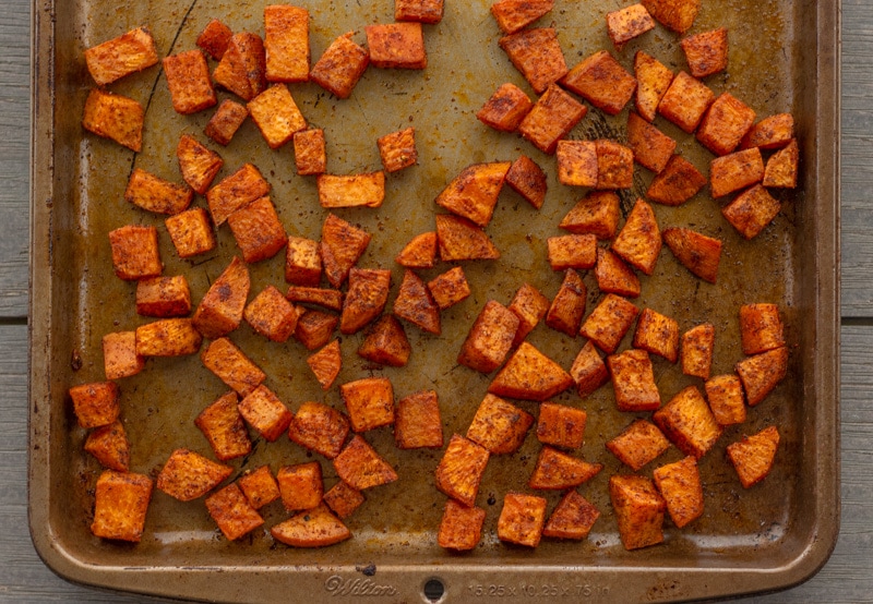 Sheet pan with baked diced sweet  potaotes.