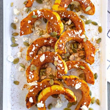 Feature image of roasted delicata squash on a white plate.