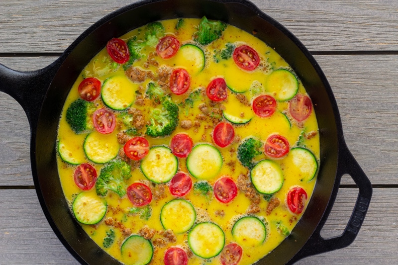 Unbaked frittata in a cast iron skillet.