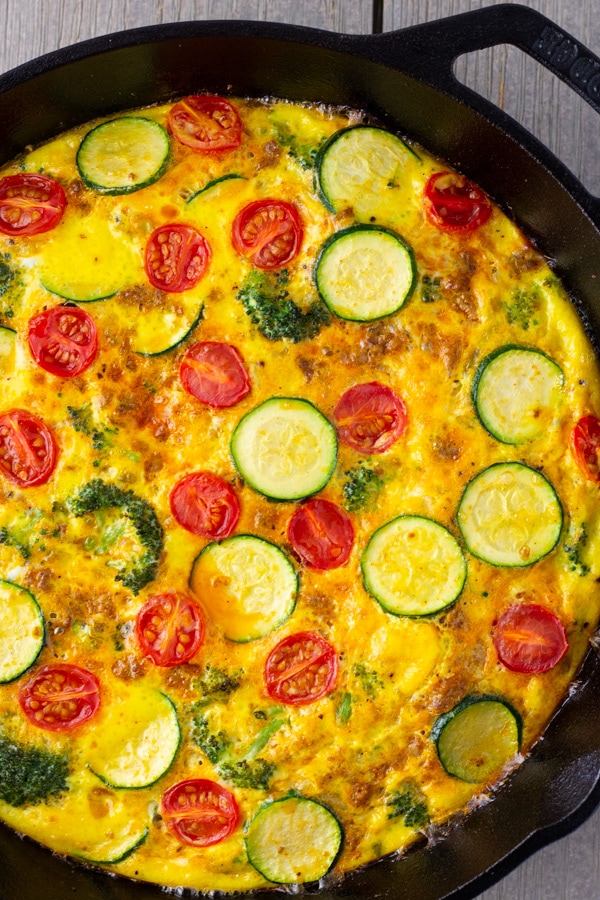 Overhead view of frittata out of the oven in a cast iron skillet.