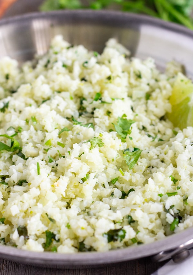 Stainless steel skillet with cilantro lime cauliflower rice.