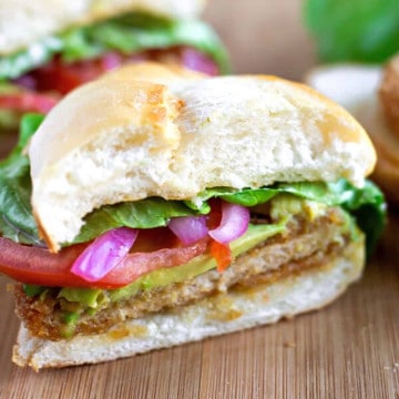 Sandwhich sliced in half on a cutting board.