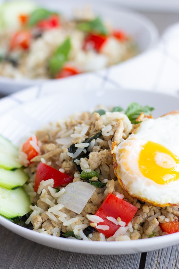 Two white bowls with finished Thai Basil Fried rice and topped with a fried egg.