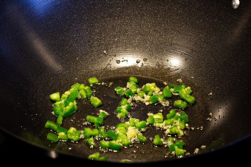 Cooking garlic and jalapenos in a wok
