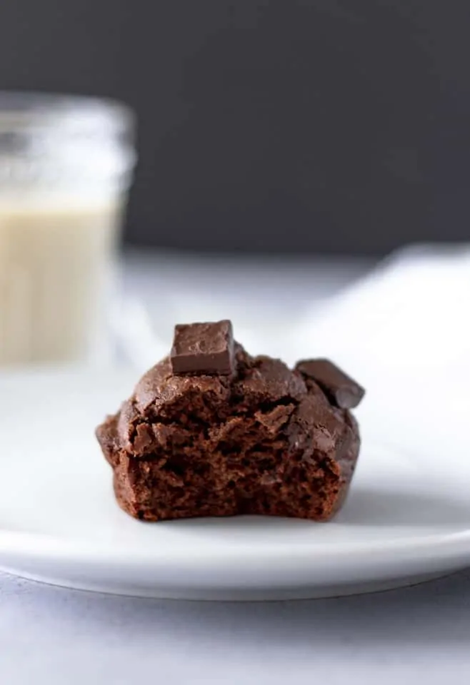 Muffin on plate with a bite taken out of it.