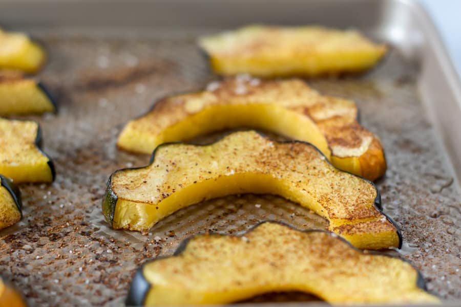 Roasted acorn squash halves on a baking sheet