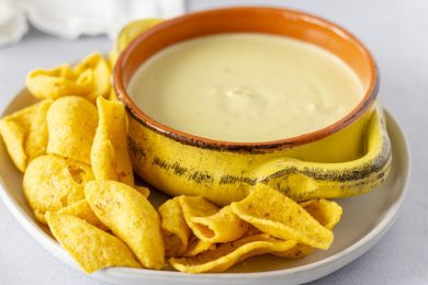Queso in a bowl with corn chips on the side.
