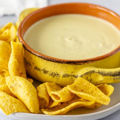 Queso in a bowl with corn chips on the side.