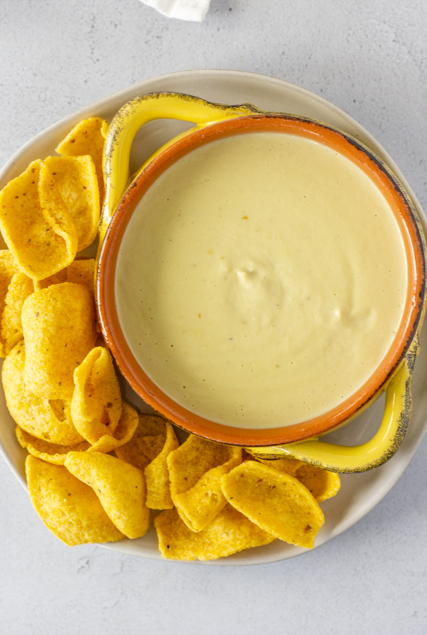 Queso in a bowl with corn chips on the side.