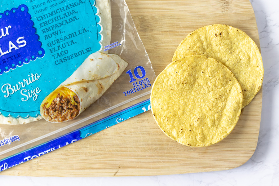 Burrito size flour tortilla and 2 crunchy tostadas on a cutting board.