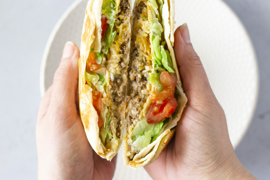 Hand holding crunchwrap open.