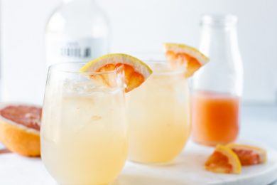 Landscape view of cocktail in stemless wine glasses and garnished with grapefruit slices.