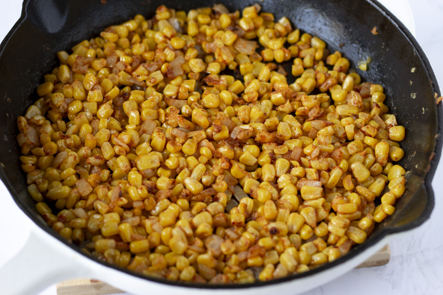 Corn cooking in a cast iron skillet.