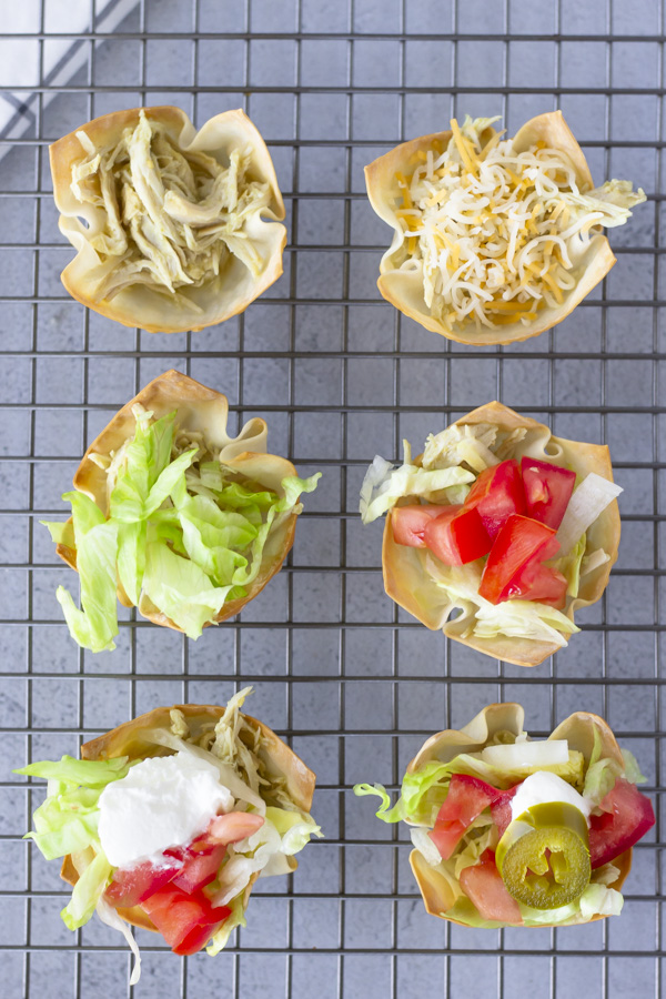 Overhead view of taco cups on a wire baking rack.