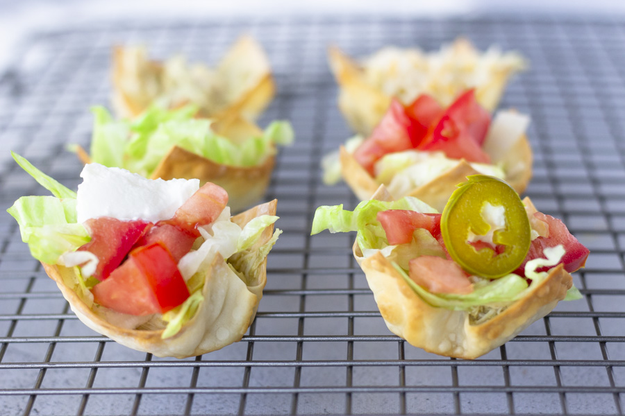 Taco wonton cups on a baking rack.