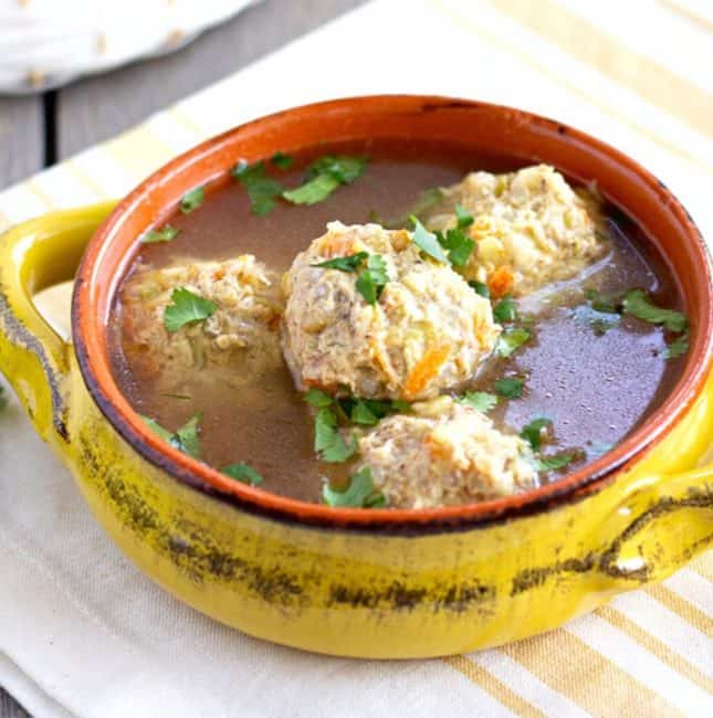 Mexican meatball soup in a yellow bowl.