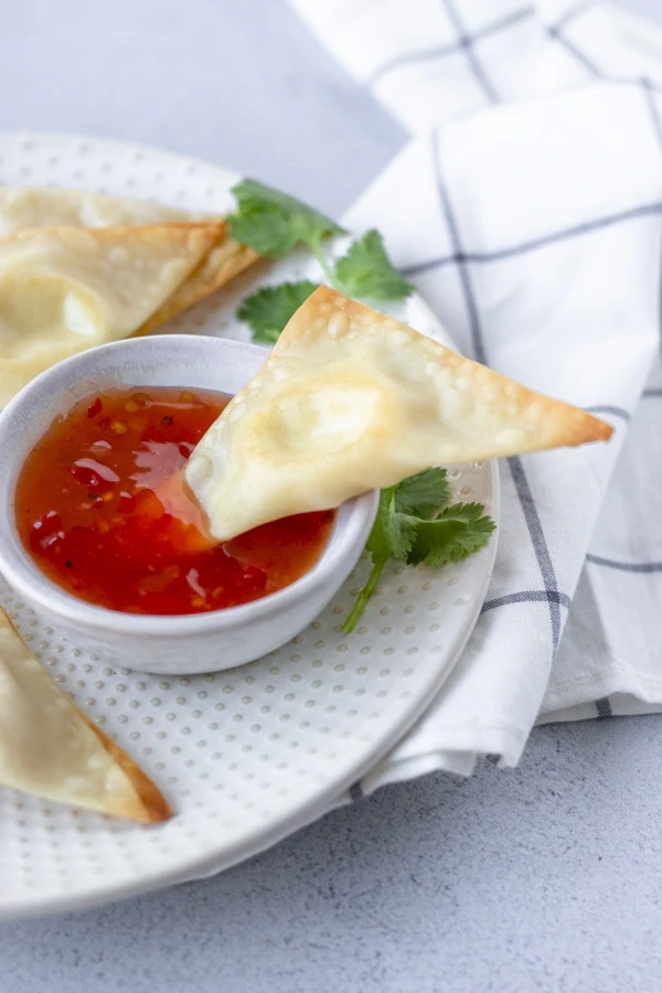 Wonton dipped in sweet chili sauce.