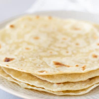 Stack of tortillas on a white plate