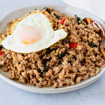 Feature image of bail pork on a white plate with a fried egg on top.