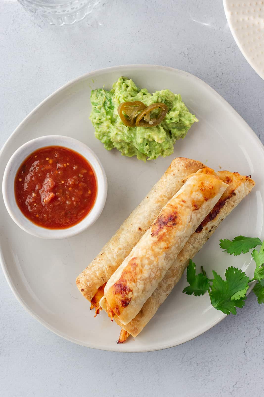 Overhead view of 3 flautas on a plate.