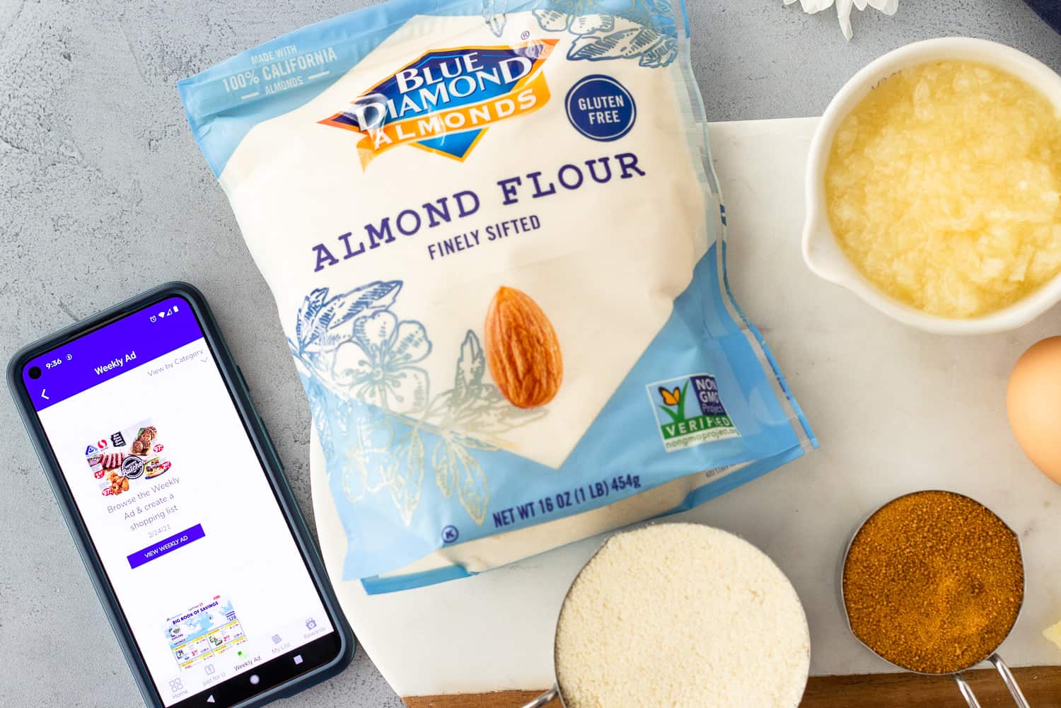 Cell phone with the Albertson's app and Almond Flour package with other ingredients.