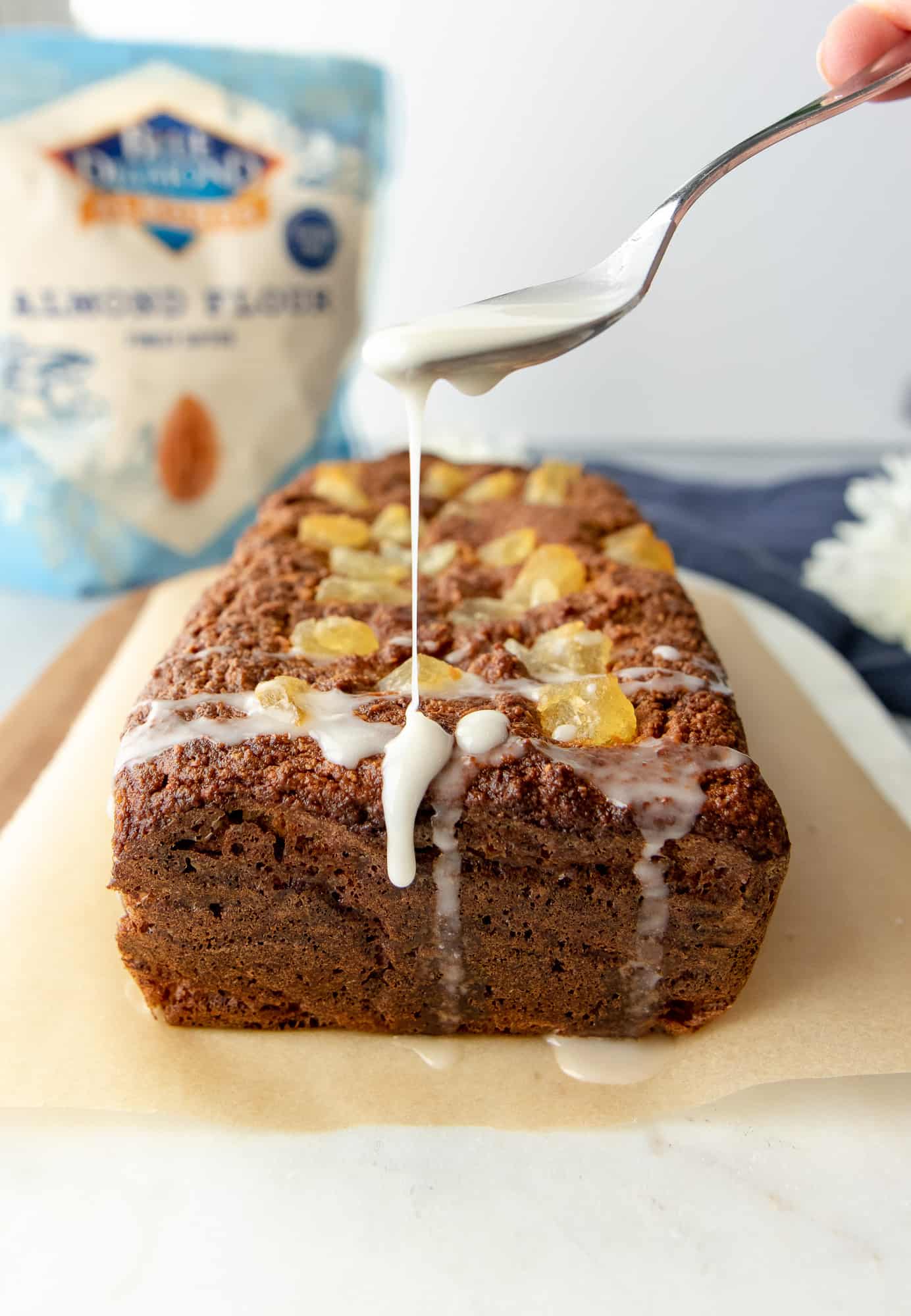 Pineapple loaf whole with spoon drizzling coconut cream on top.