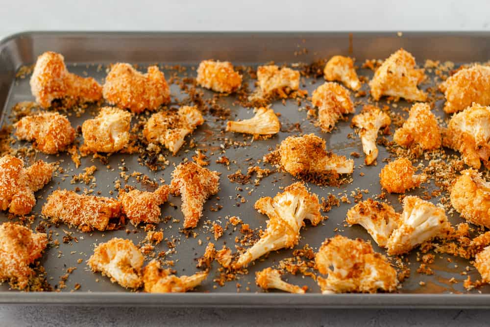 Panko coated buffalo cauliflower on a baking sheet.