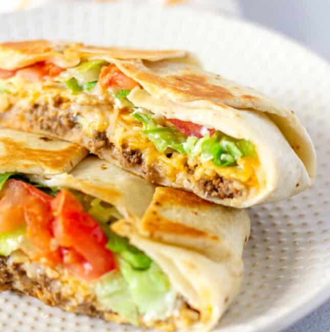Crunch Wrap sliced in half and stacked on a plate.