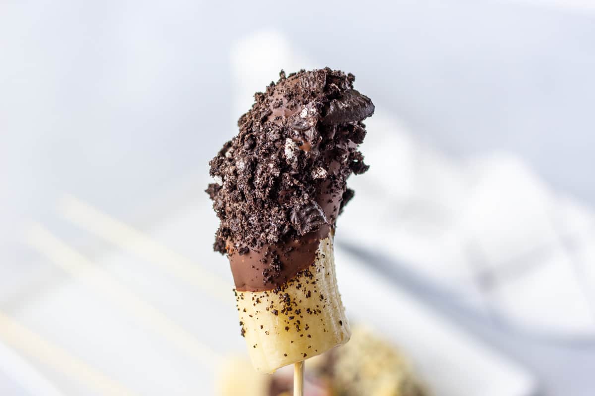 Single dipped chocolate banana with crushed oreos