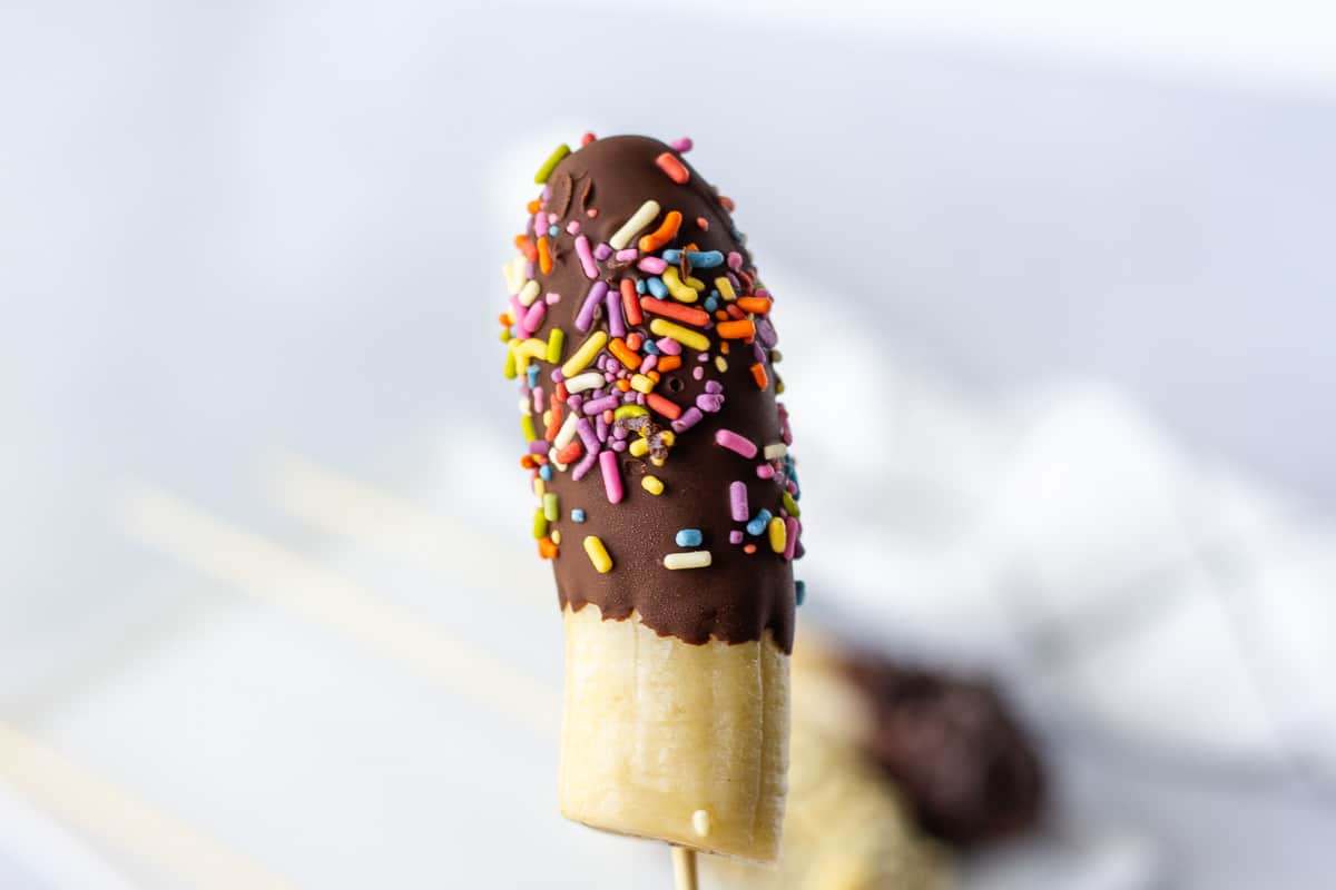 Single dipped chocolate banana with rainbow sprinkles