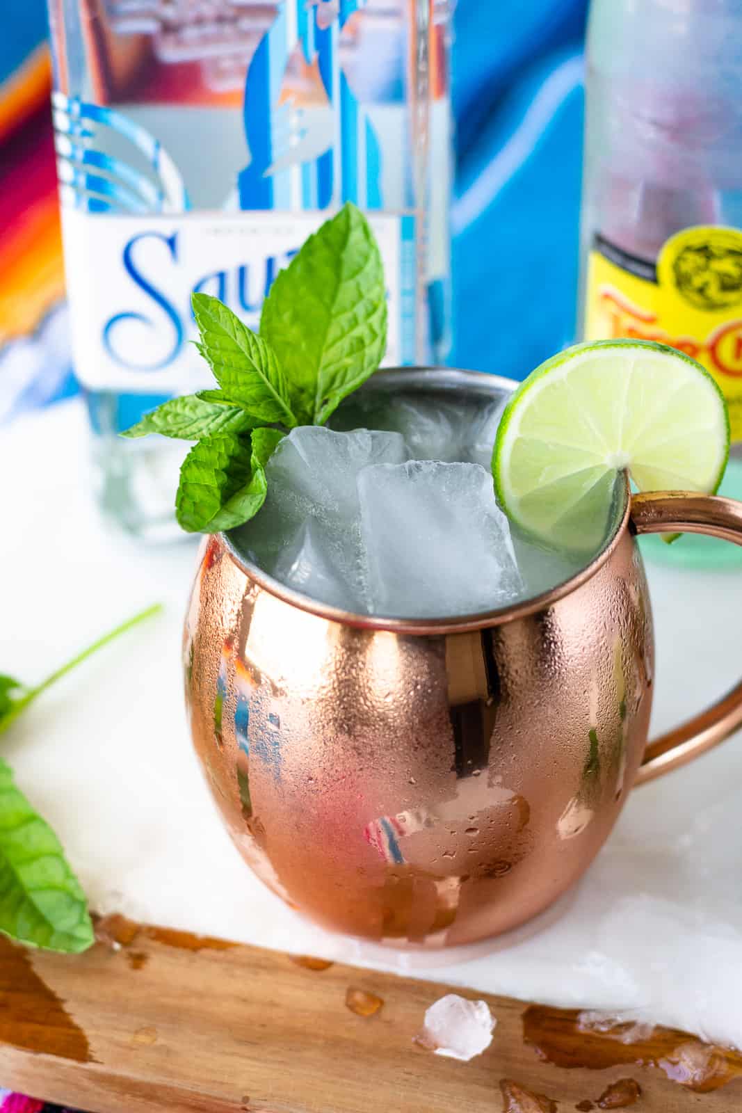 Completed Mexican Mule in a copper cup with a min and lime garnish.