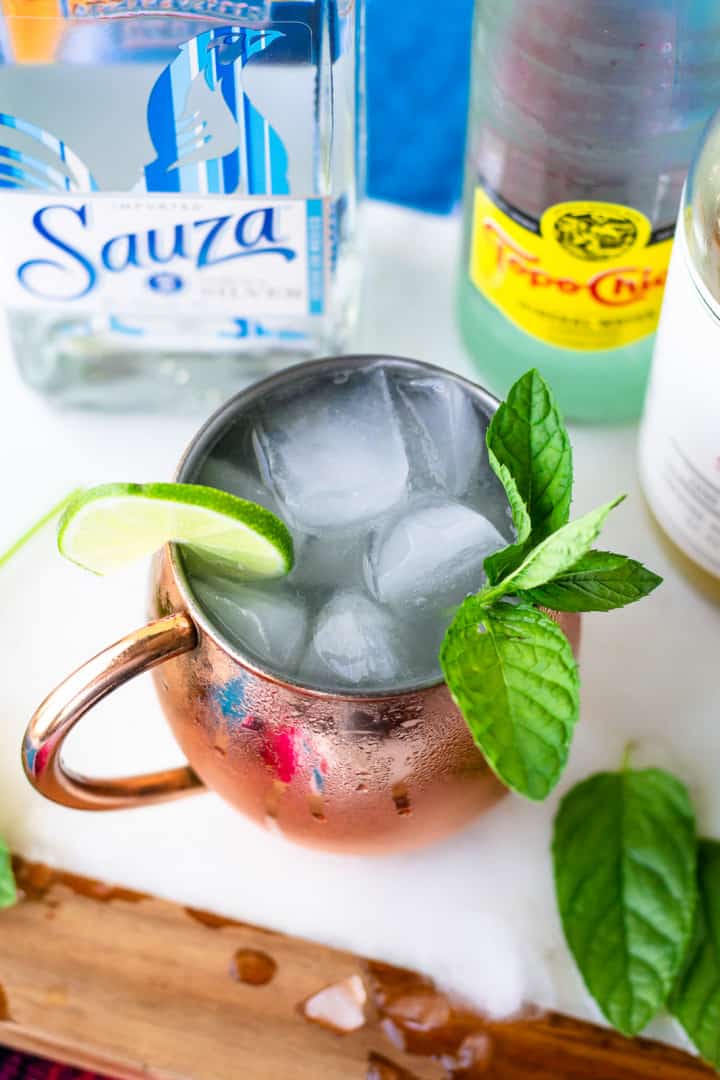 Overhead view of cocktail in a copper mug with a mint and lime slice garnish.