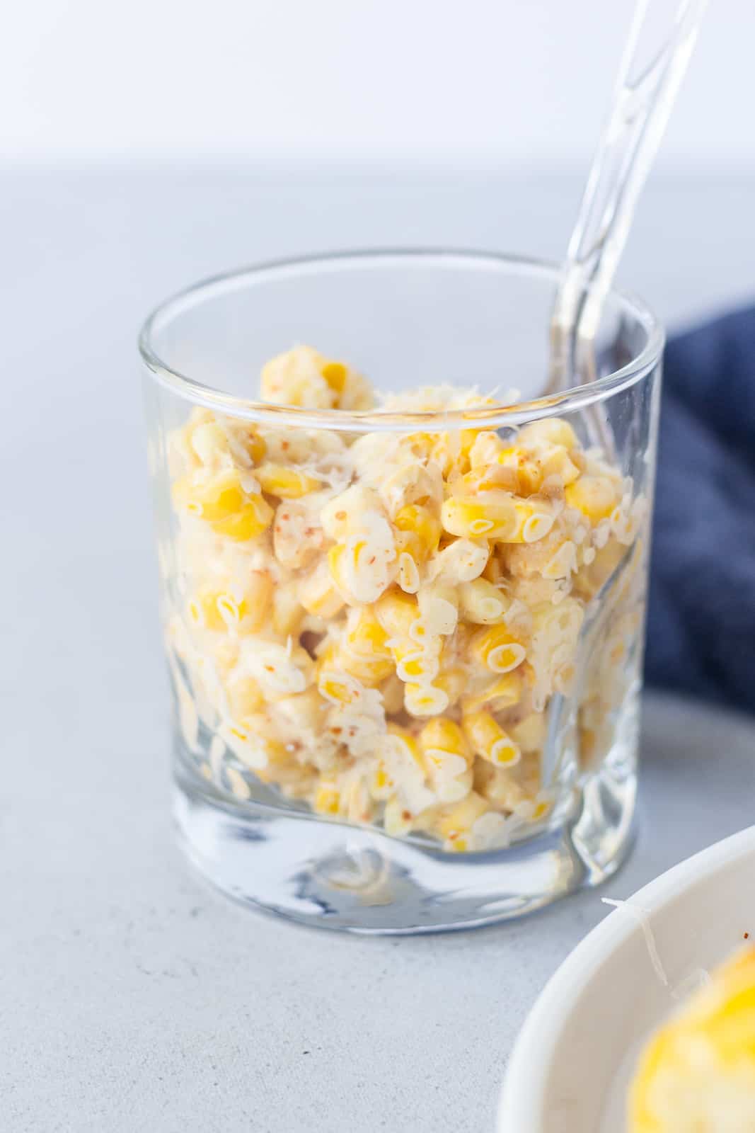 Shaved corn on a glass with a spoon.