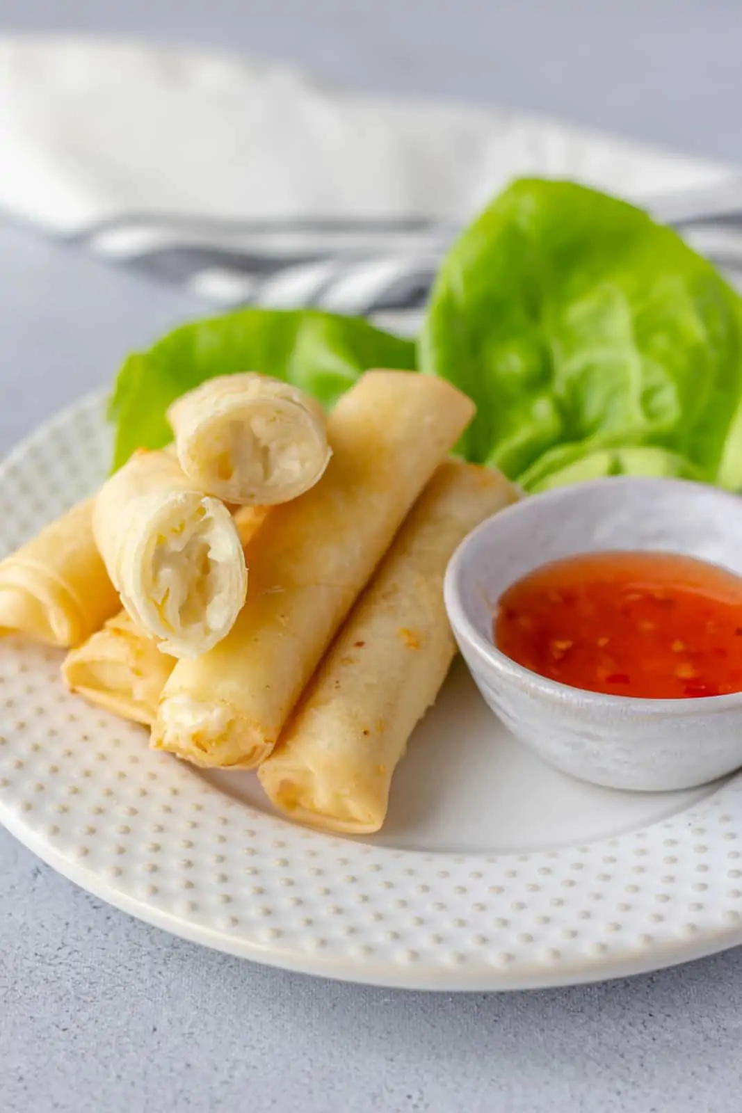 Cheese Rolls on a plate with butter lettuce and sweet chili dipping sauce.