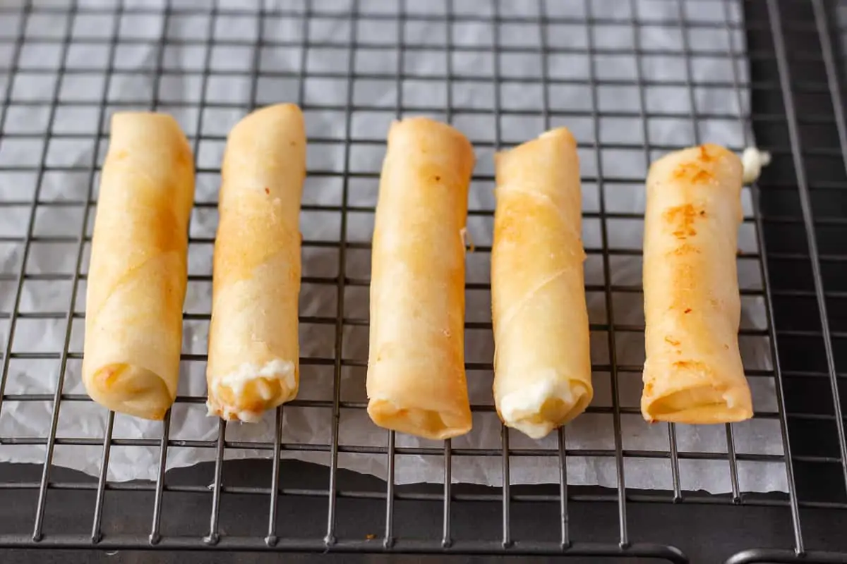 Fried Rolls on a wire baking sheet.