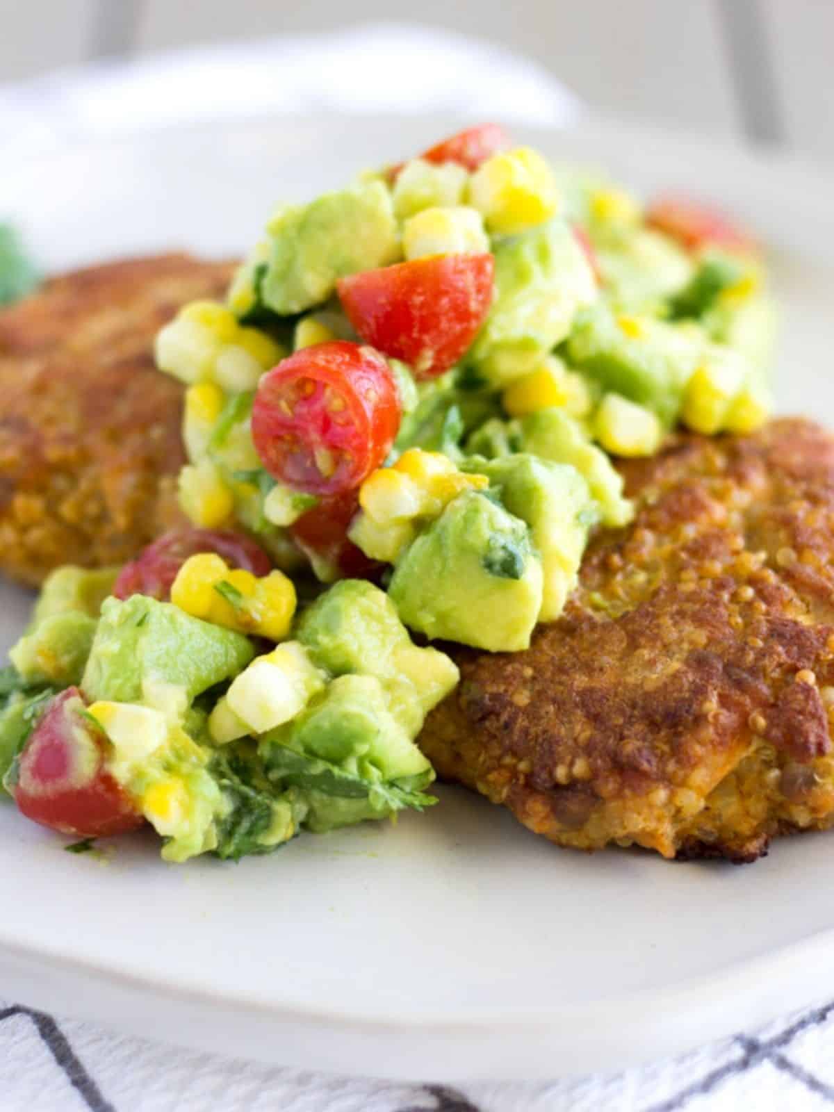 Up close view of avocado, corn, and tomato salsa on top of salmon cake.